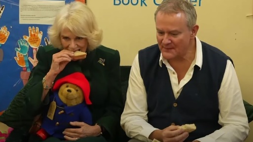 Queen Consort Camilla and actor Hugh Bonneville eating marmalade sandwiches. Credit: YouTube.